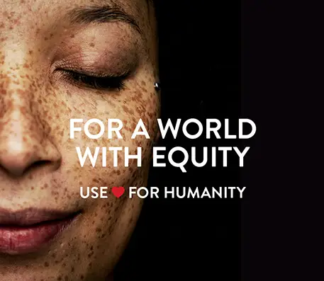 Woman with freckles has her eyes closed with the text For a World with Equity Use Heart for Humanity