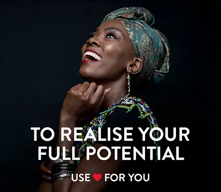 Woman laugh and looking towards the sky on a black background with the test To Realise your Full Potential Use Heart for You