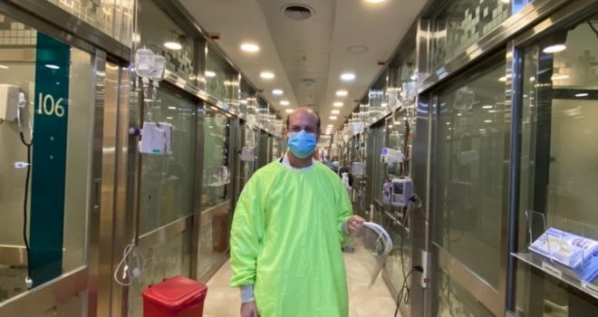 Medical professional in face mask and a gown working on a hospital ward
