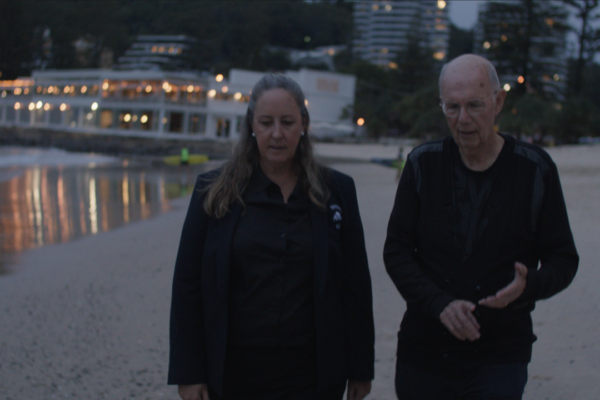 A gentleman and lady take a walk down the beach