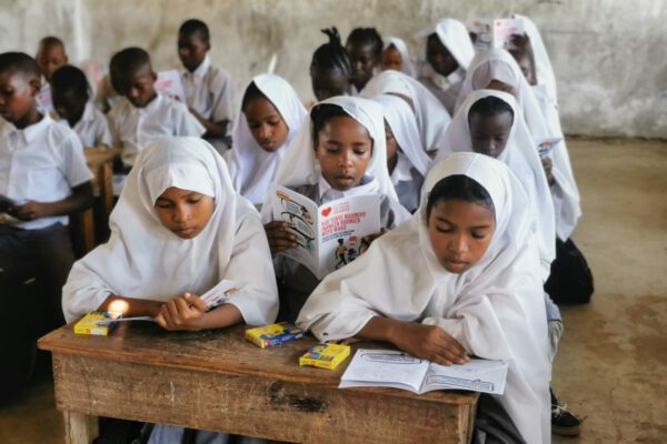school children sat in a classroom reading heart health documentation