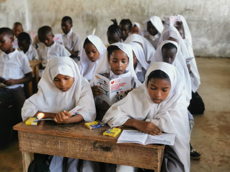 school children sat in a classroom reading heart health documentation