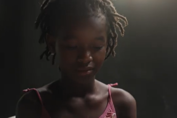 A young child looking towards to floor
