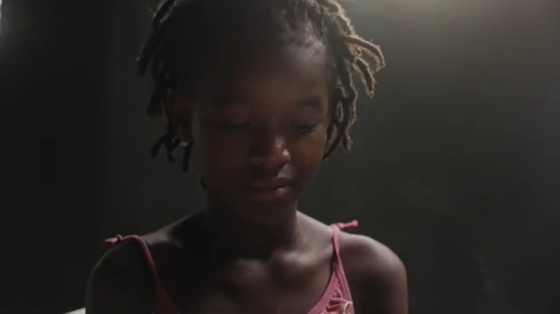 A young child looking towards to floor