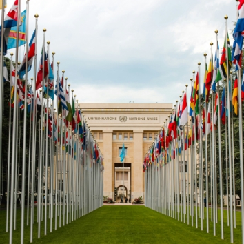 Geneva showing the UN headquarters building with all the nation flags on flag poles