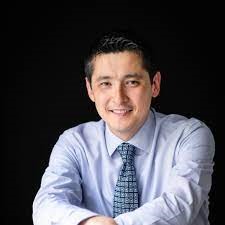 Portrait image of a man in blue shirt and tie