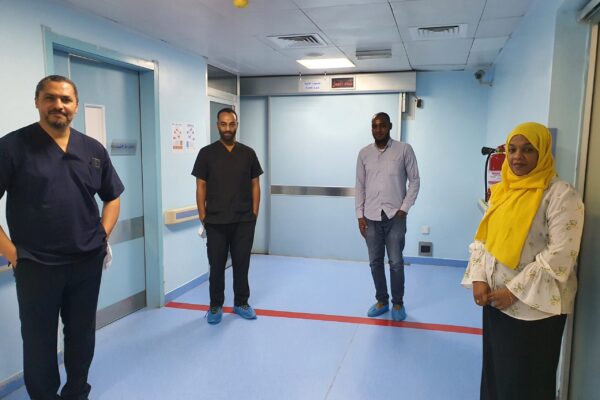Prof. Ahmed Suleiman stands alongside colleagues in a hospital while social distancing due to COVID-19