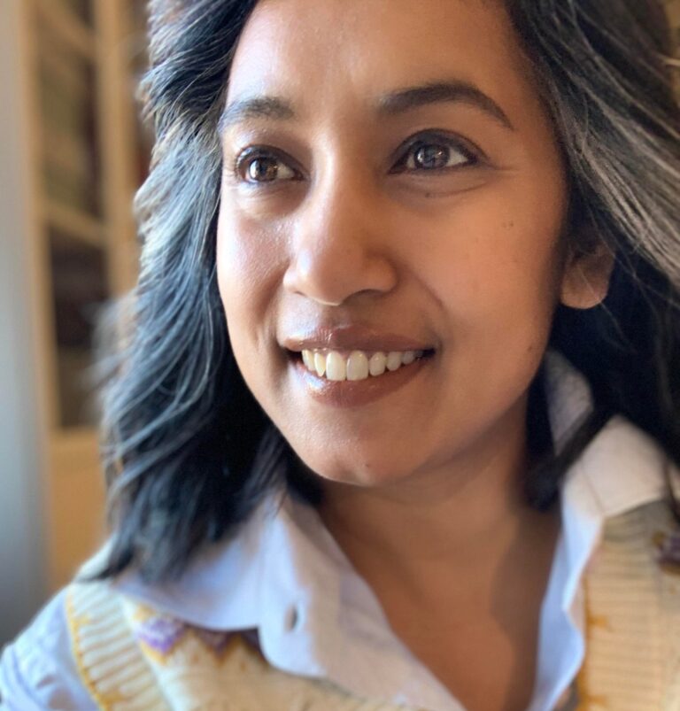 A portrait image of Protiva Gyllerup wearing a sweater and shirt