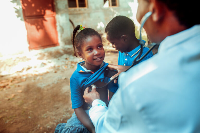 Doctor with a stethoscope listening to a girls chest