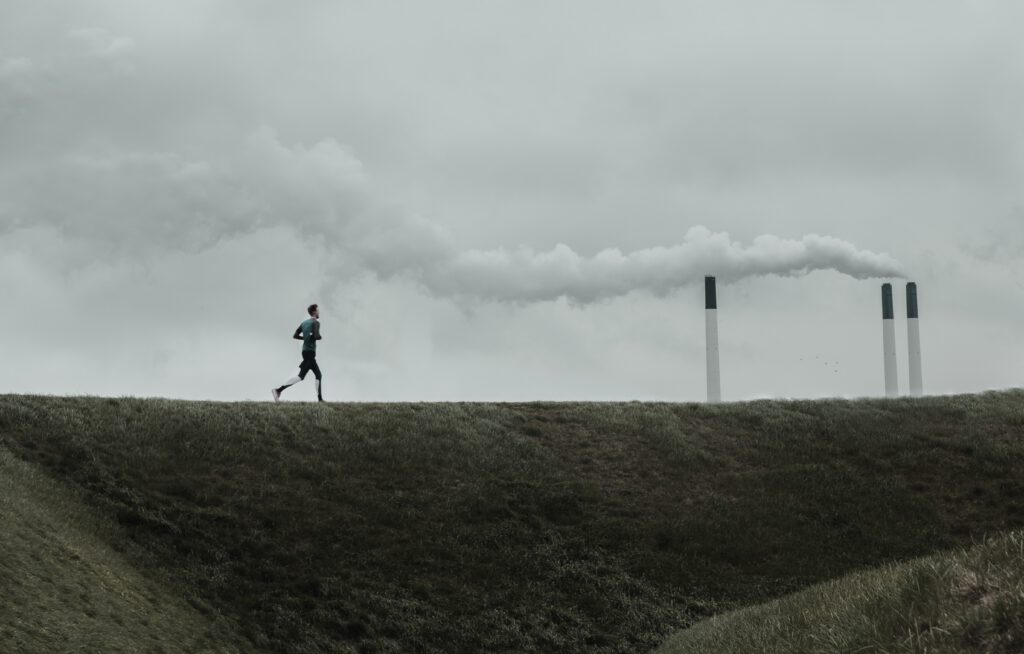 A man running next to a refinery