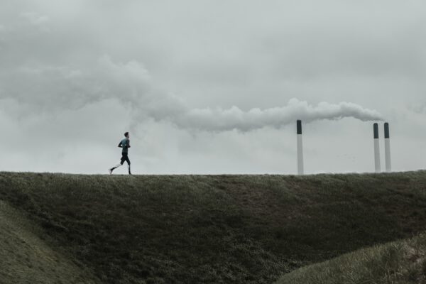 A man running next to a refinery