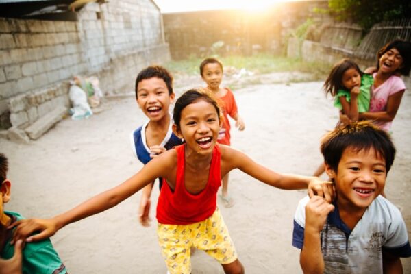 children smiling and enjoying playing amongst themselves in the outdoors