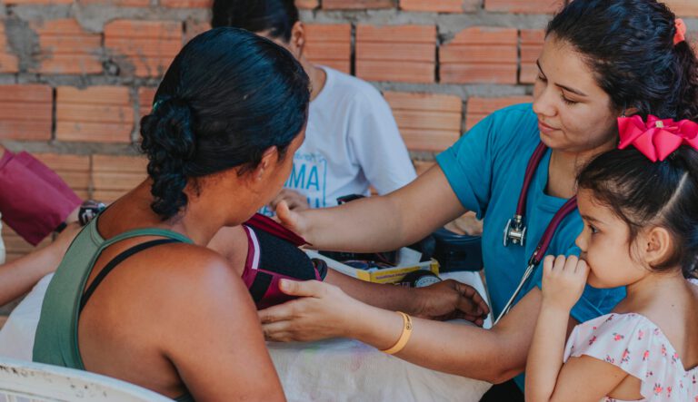 A medical professional is screening a mother and her child for heart diseases