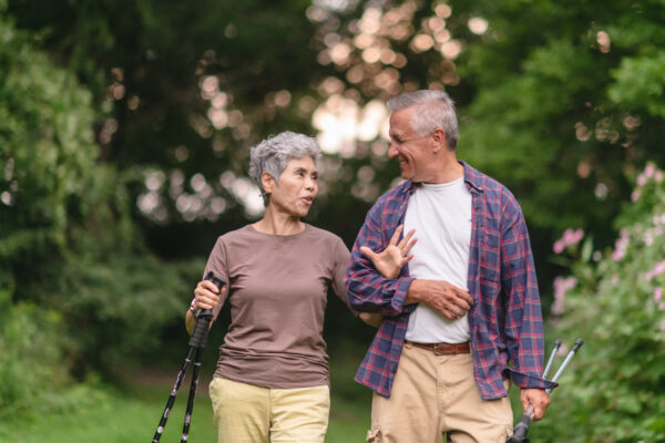 a happy senior couple taking a hike through the countryside and surrounded by trees
