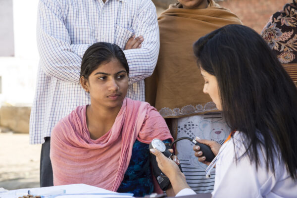 A female medical professional is doing examinations on a female patient