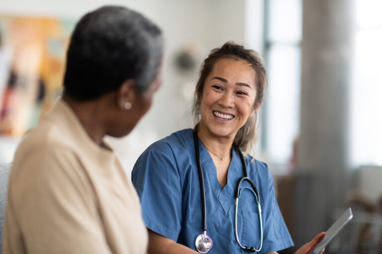 A medical professional smiling and greeting her patient