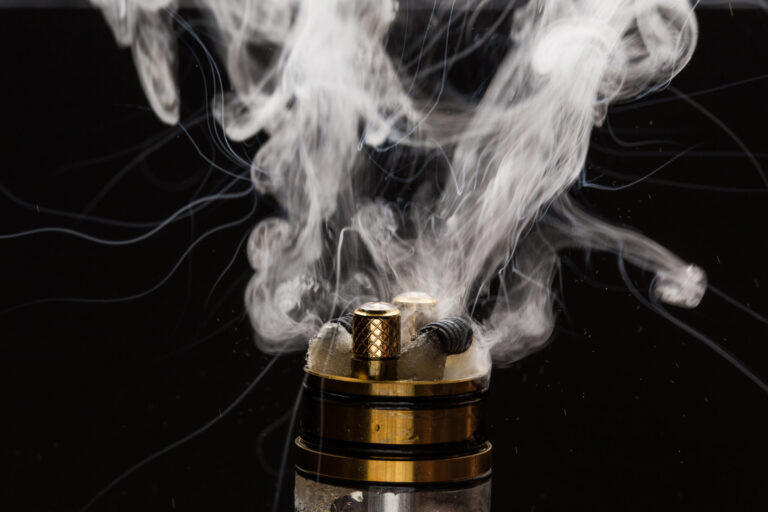 Vape close-up with vapour on a black background