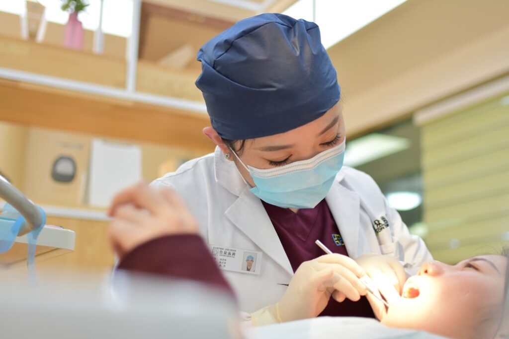 A photo of a healthcare professional looking inside the mouth of a child