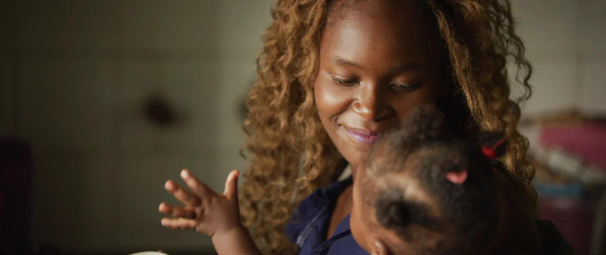 A lady holding a toddler smiling