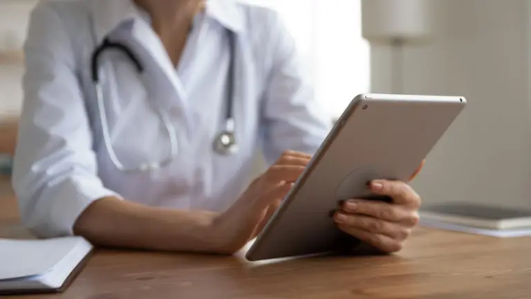 A healthcare professional using a tablet device