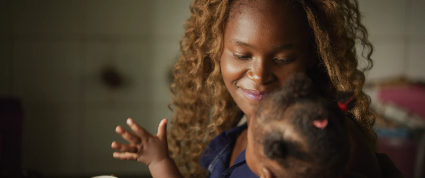 A lady holding a toddler smiling