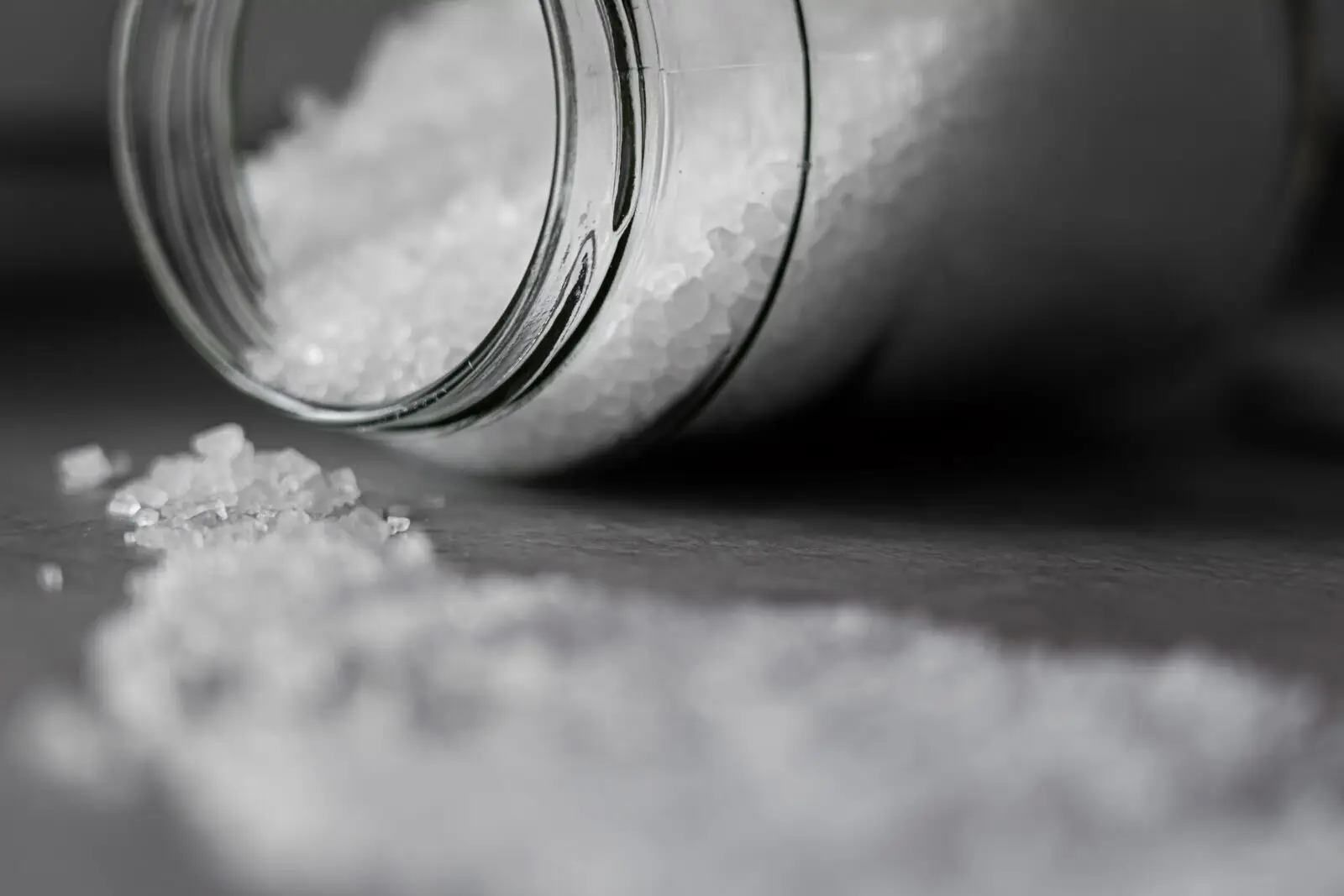 Jar of salt on its side with the salt spilled out - heart health