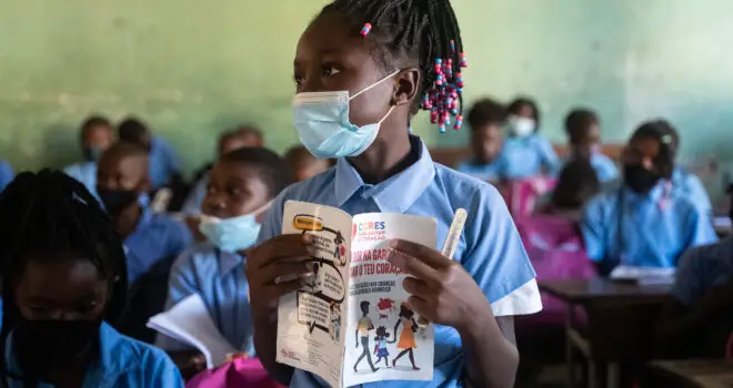 a young girl from Mozambique stood in a classroom while learning about rheumatic heart disease
