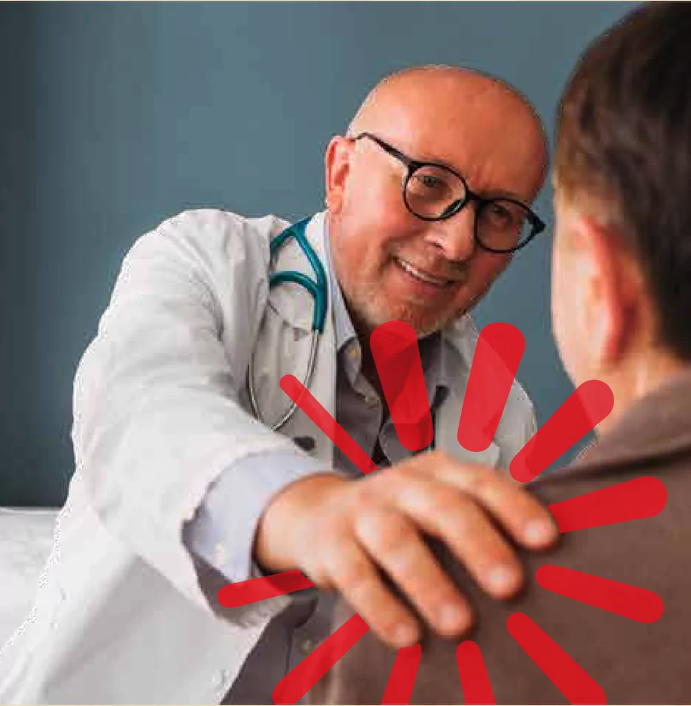 A doctor putting his hand on a patients shoulder in a caring way