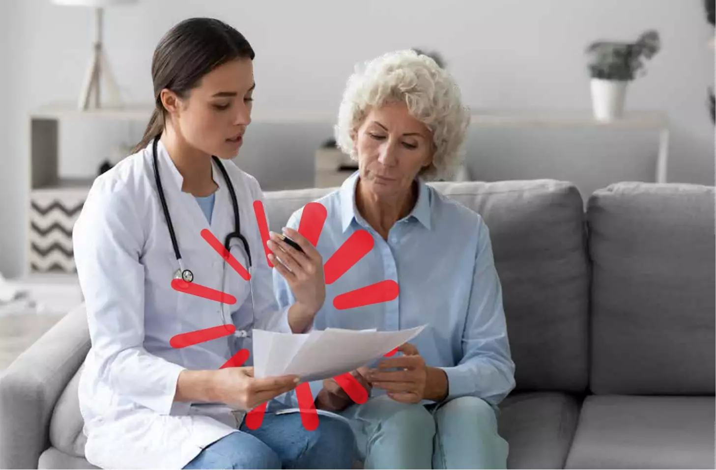 A female doctor sat on a sofa with a patient sharing a report to them