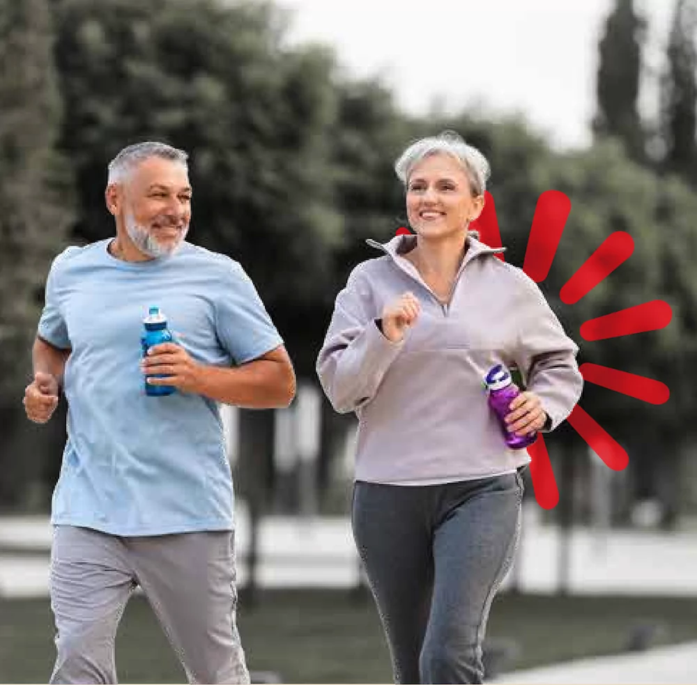 A woman and man running down a road holding water bottles - World Adherence Day 2026