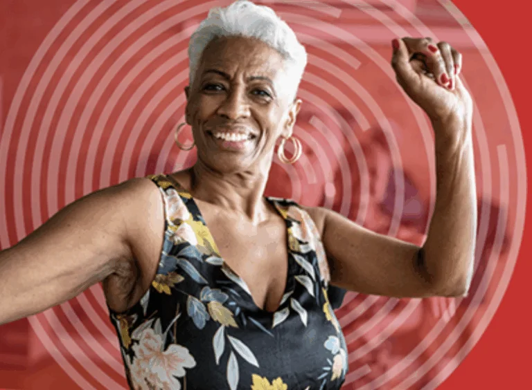 A woman smilng with her hands up in the air