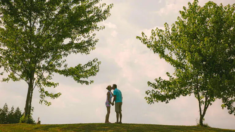 A couple kissing between 2 trees. Beats of change