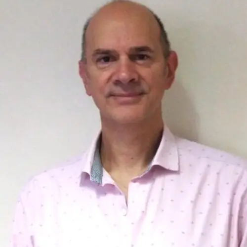 Portrait image of Dr César Berenstein wearing a pink shirt