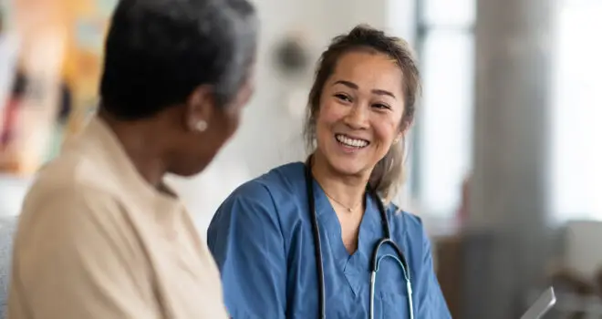 A medical professional smiling and greeting her patient