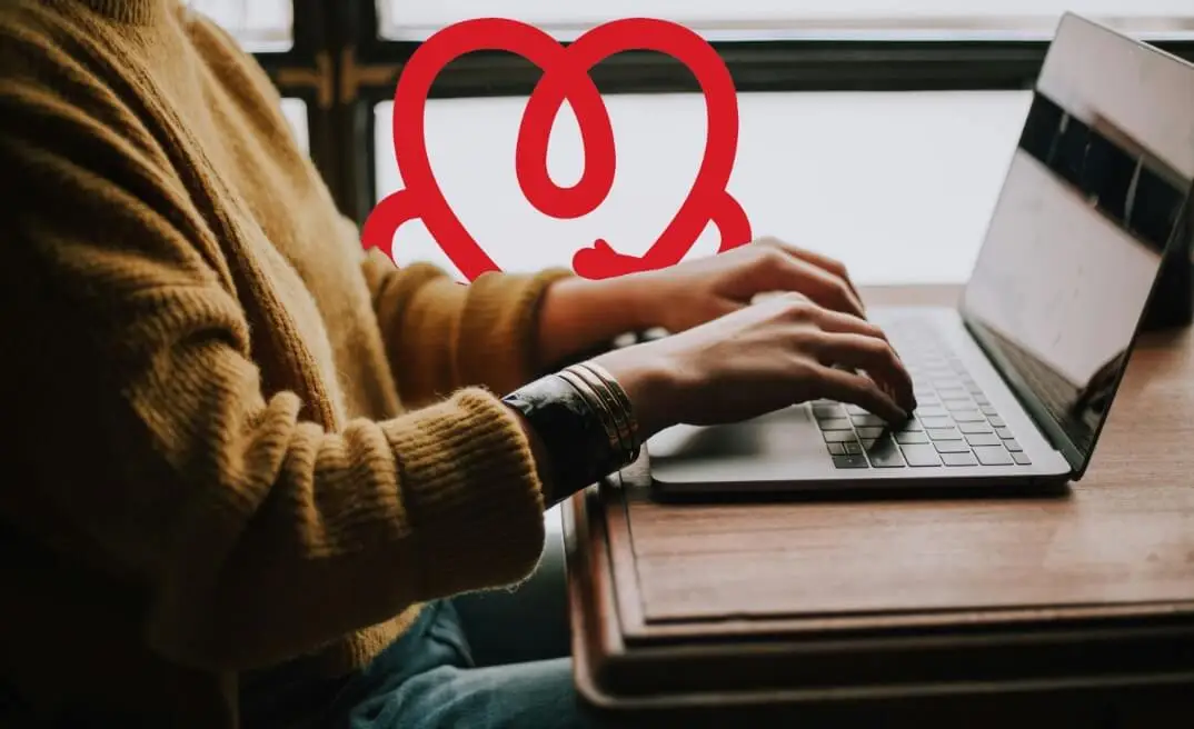 Person using a laptop at a brown desk, working online with World Heart Federation members.